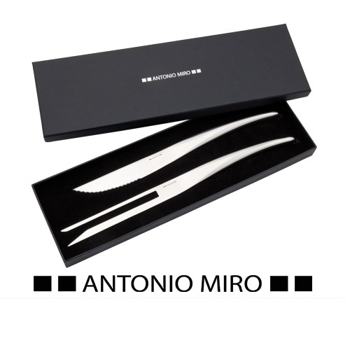 7150, Set de cocina de Antonio Miró con cuchillo de sierra y trinchador en acero inox. Presentado en estuche individual con logotipo de la marca e interior troquelado en suave espuma.