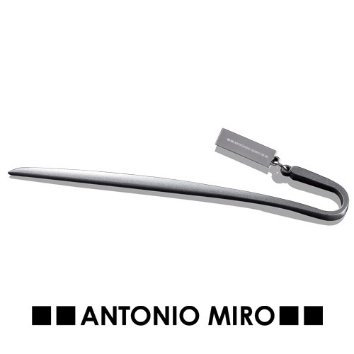 7227, Marcapáginas metálico de Antonio Miró en elegante acabado gris oscuro. Con logotipo de la marca.