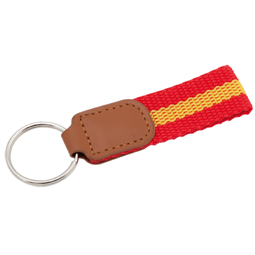 3895, Llavero de poliéster con accesorios de bandera española en la cinta y refuerzo en polipiel de color marrón.